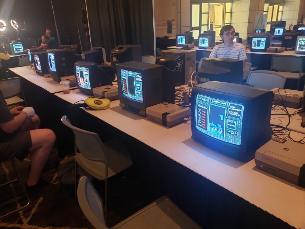 A row of CRT TVs and NES Consoles